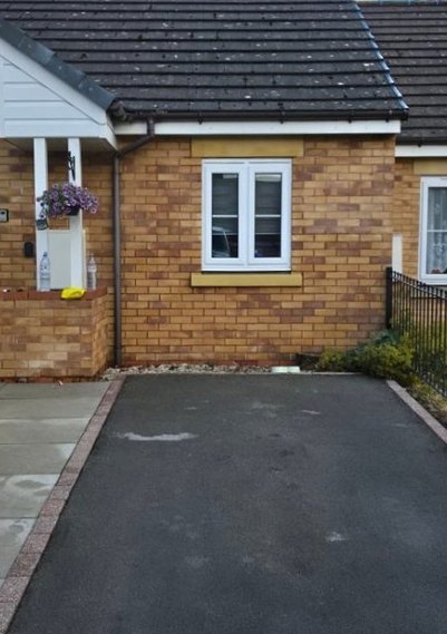 After: the same tarmac driveway cleaned back to a deep black
